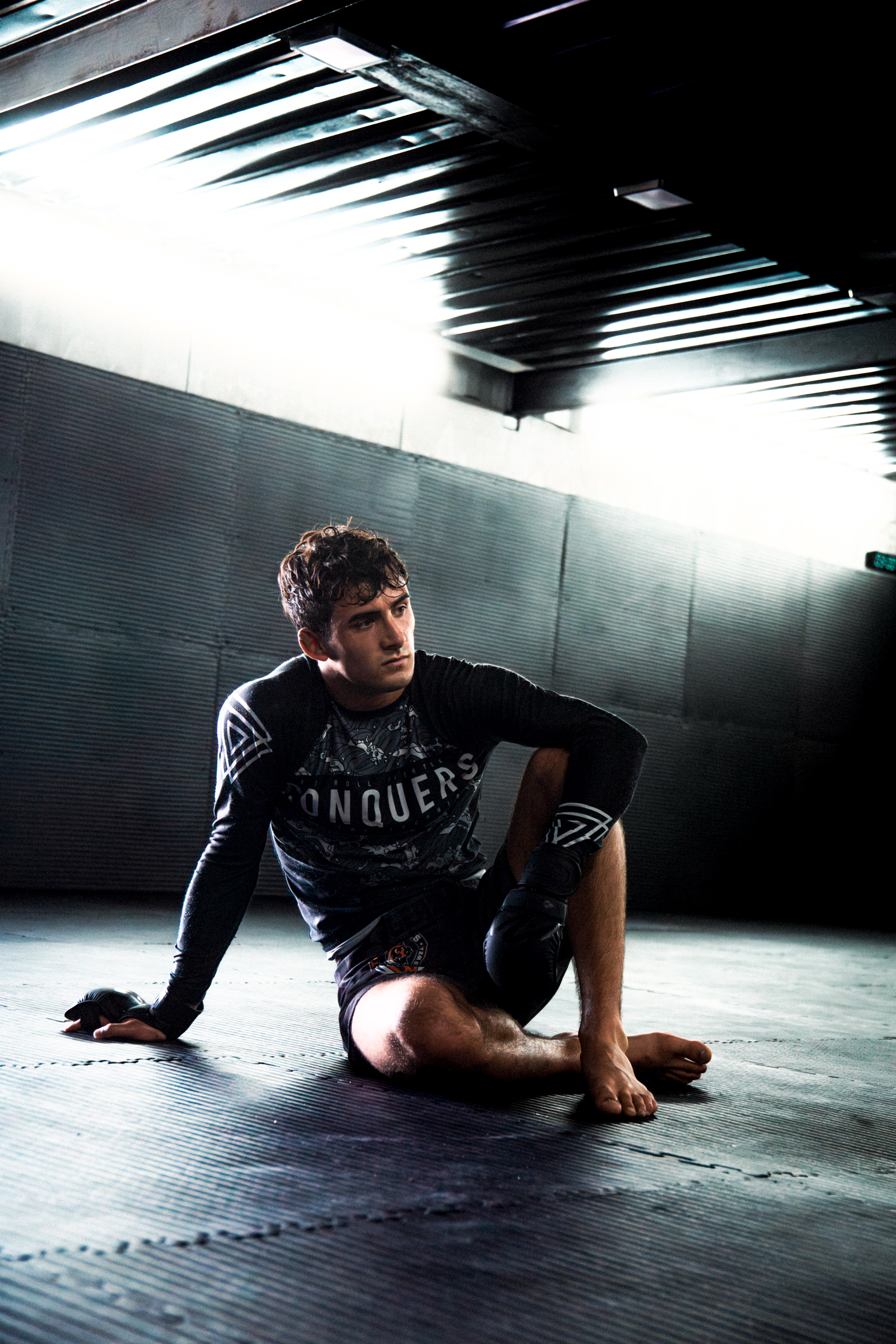 Lucca sentado en el gimnasio con iluminación dramática